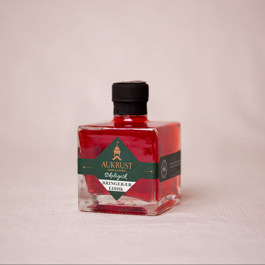 Flaske med økologisk bringebæreddik fra Aukrust Gård i Lom, laget på norske og økologiske bringebær fra egen gård.